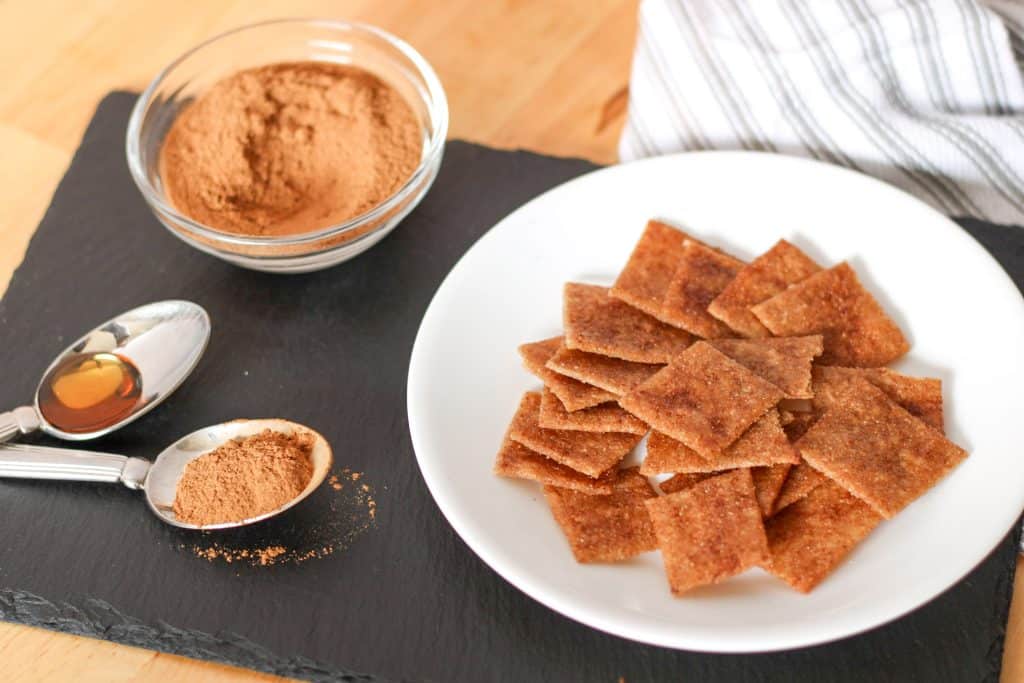 maple cinnamon crackers on plate, spoon of cinnamon and maple syrup