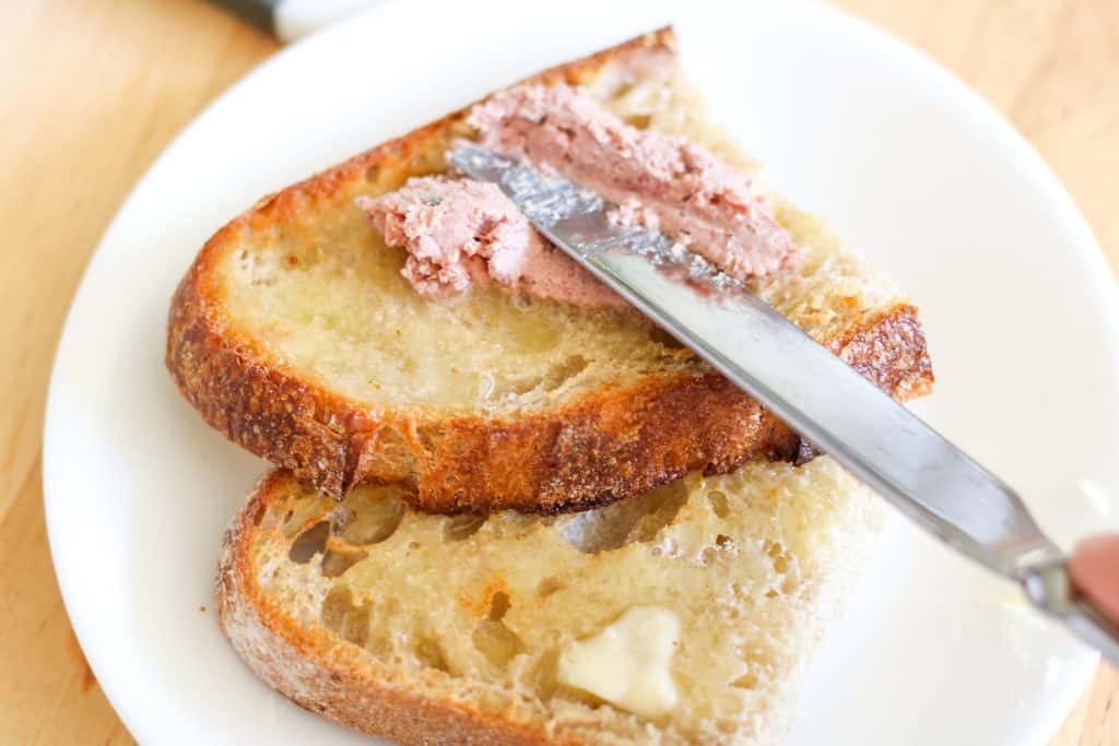 spreading pate on buttered toast