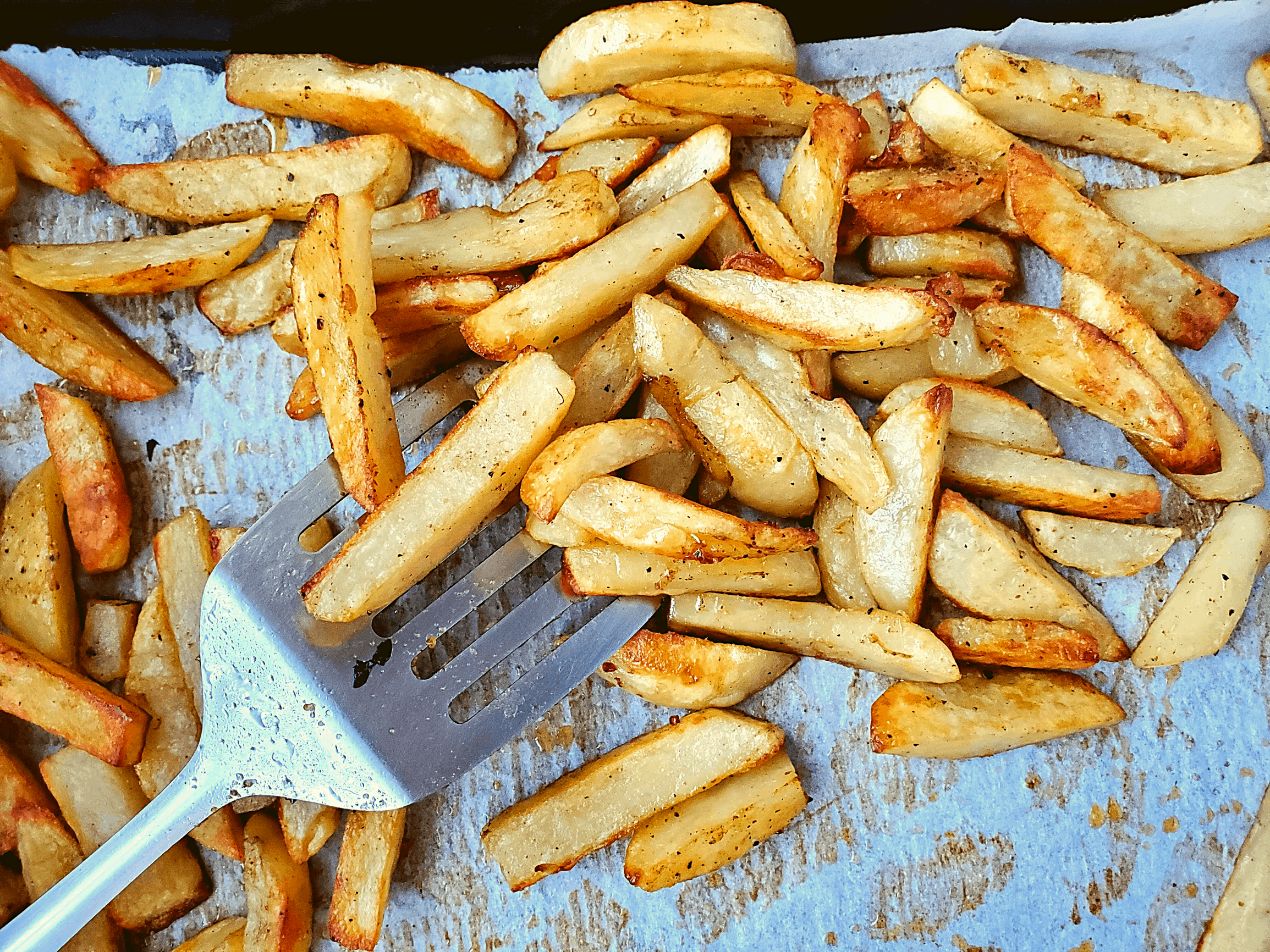crispy fries on a pan with a spatula