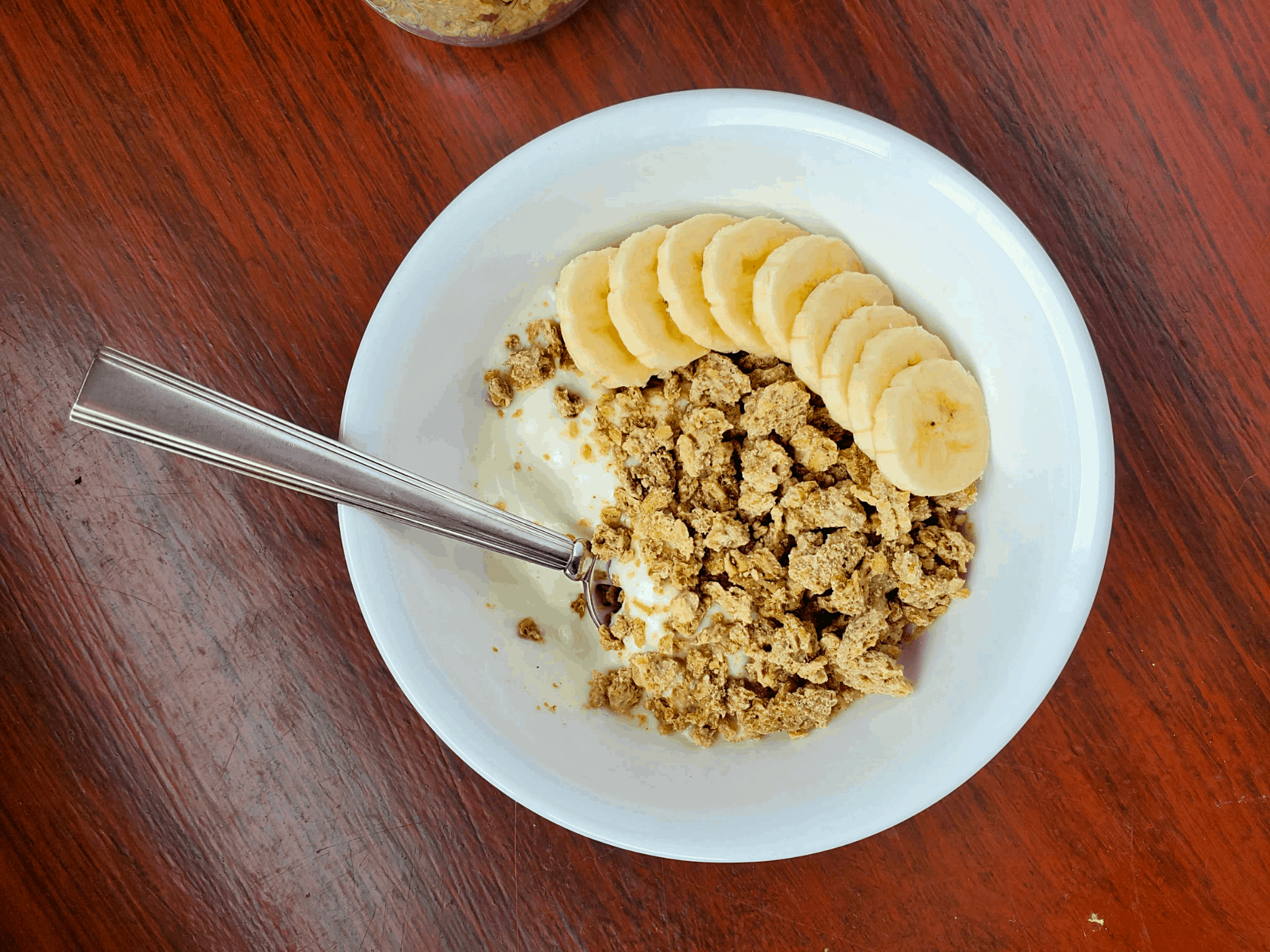 granola in a bowl with yogurt and bananas