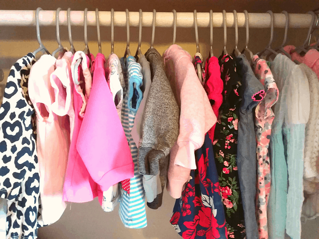 baby clothing hanging in a closet