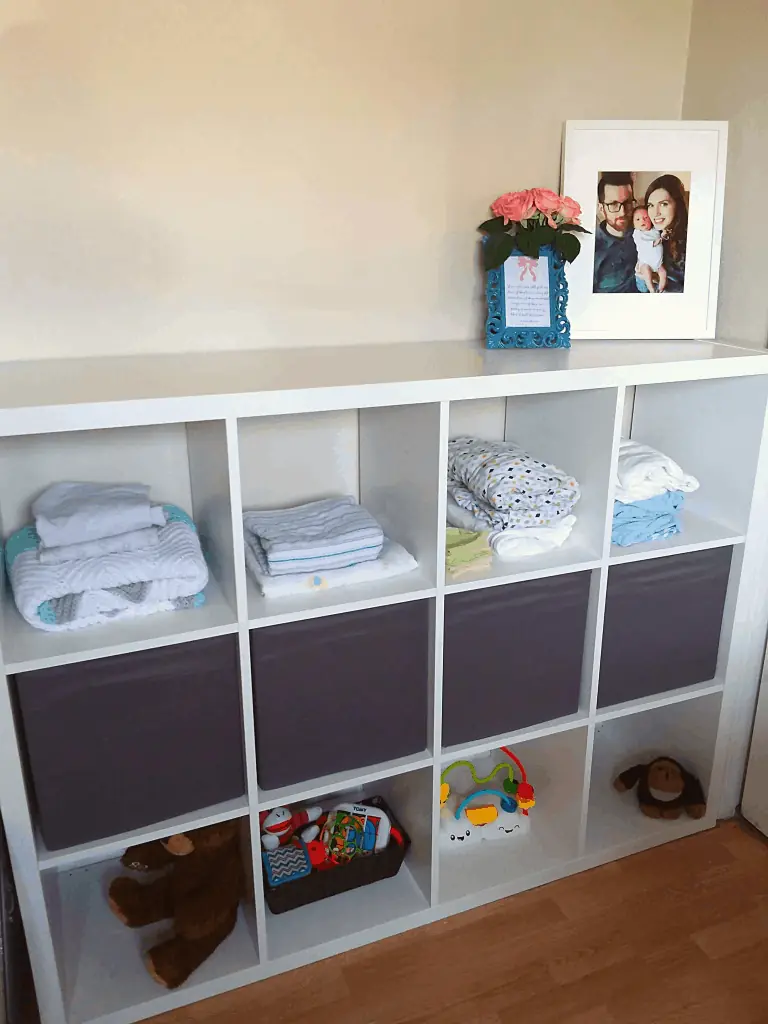Cube shelf unit filled with organized baby items