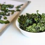 bowl of kale chips with dehydrator tray in the back