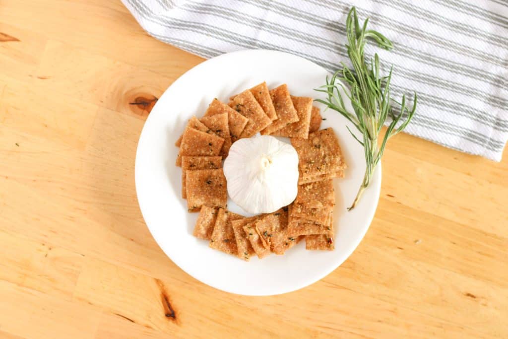 crackers on plate with garlic bulb and rosemary