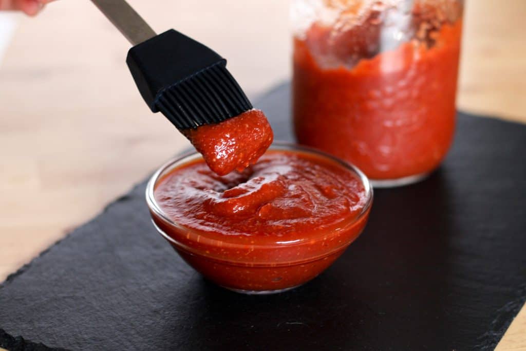 dipping brush in homemade bbq sauce