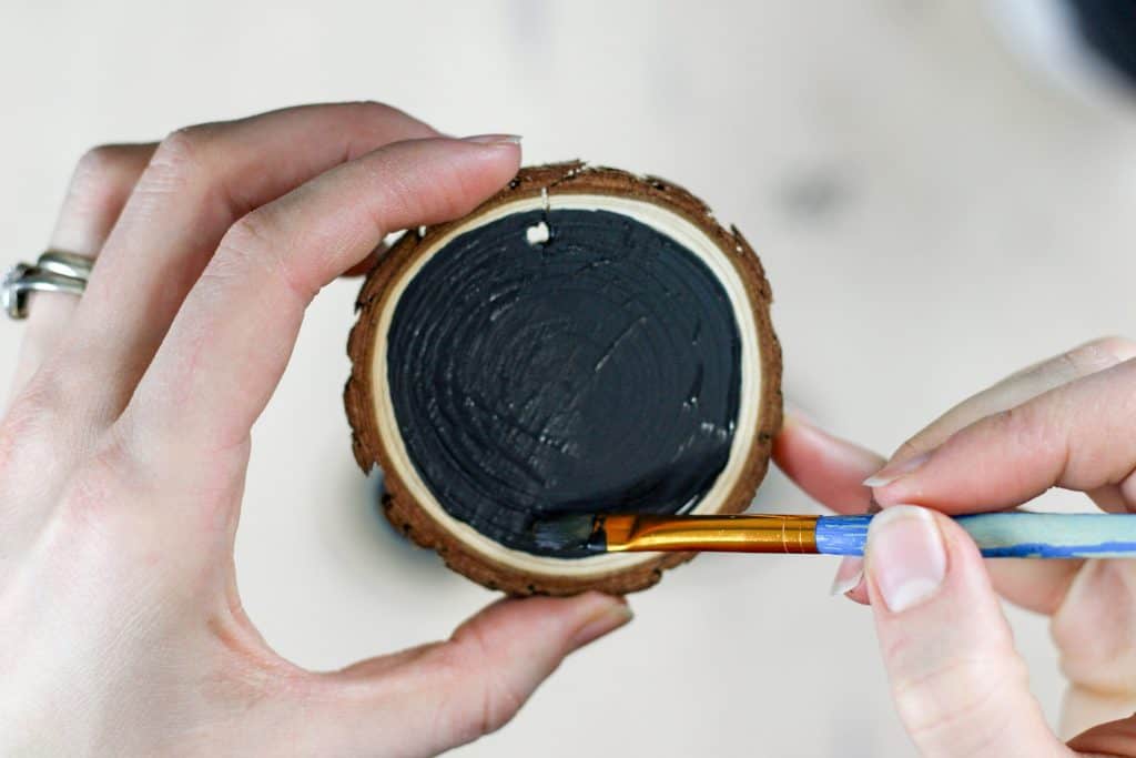 painting a black circle on a tree cookie