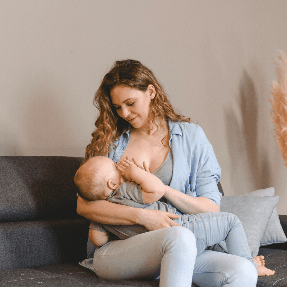 mother breastfeeding baby on couch