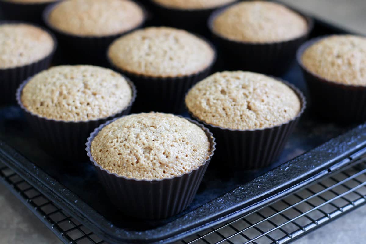 baked vanilla cupcakes on a baking sheet