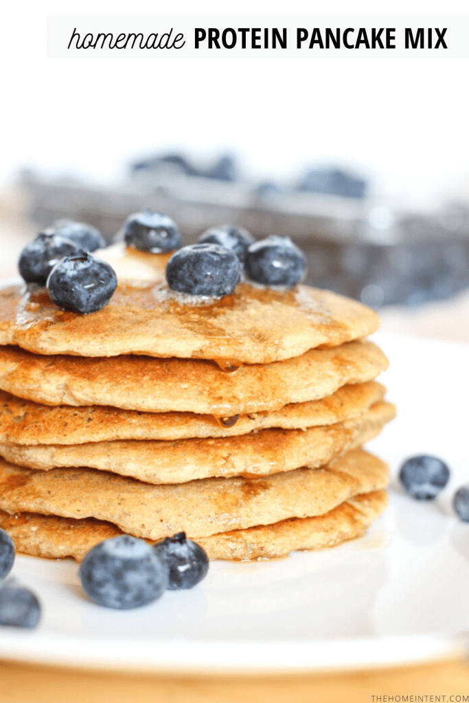 stack of pancakes on plate with butter and blueberries on top