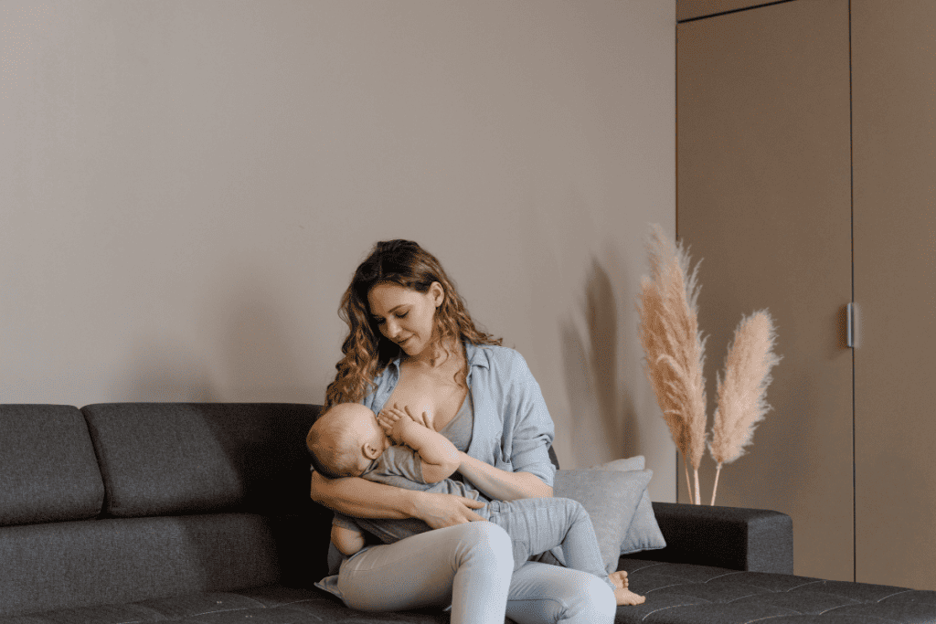 mother breastfeeding baby on a couch