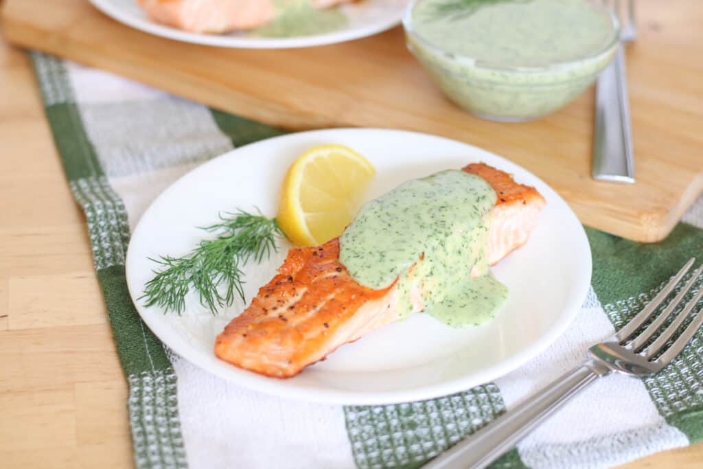 salmon fillet with lemon wedge and dill, plus a fork on the side