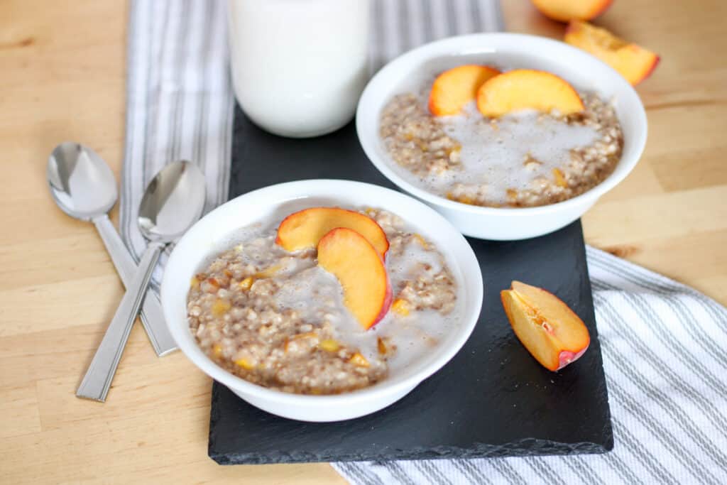 bowls of oatmeal topped with peaches and cream