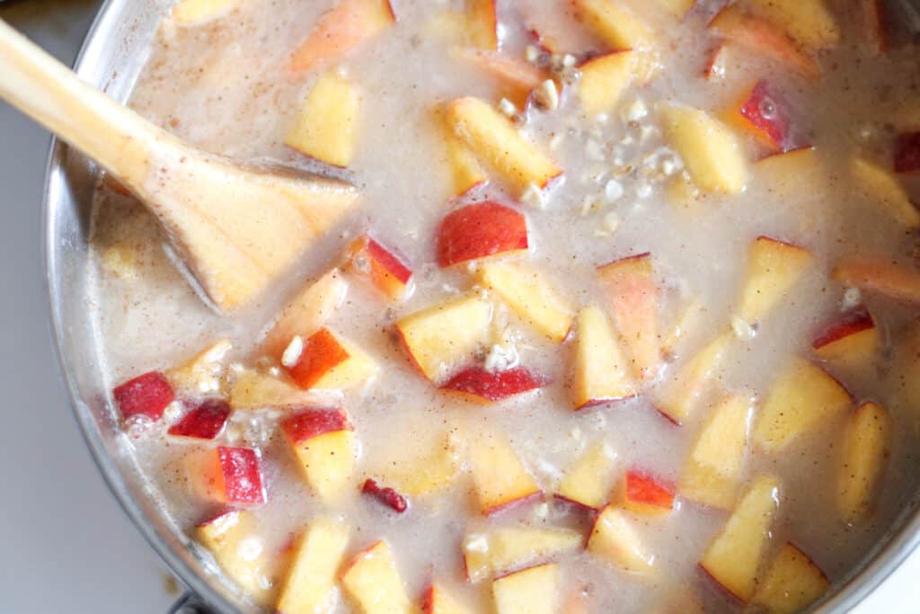 fresh peaches in a pot with soaked oats and extra water before cooking
