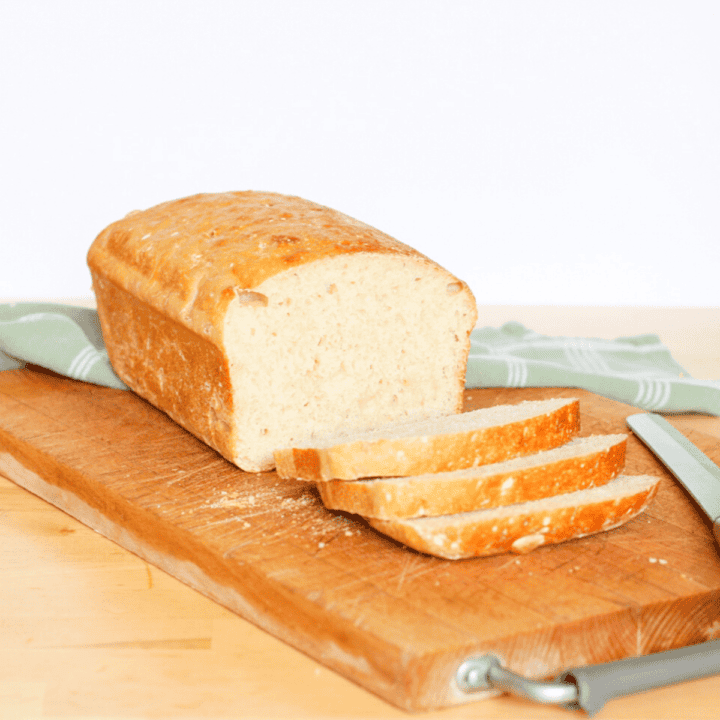 loaf of bread cut into a few slices on a cutting board