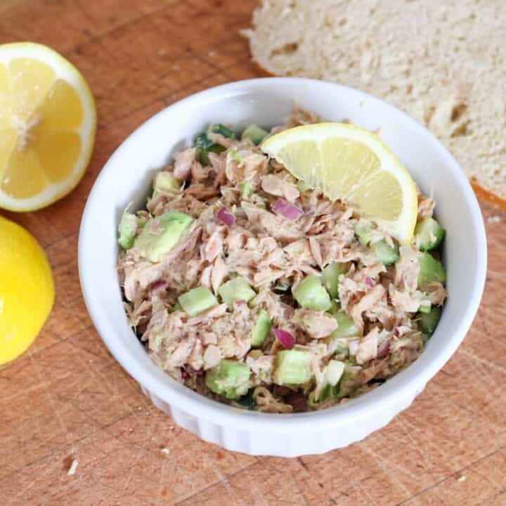 bowl of tuna salad, lemons and bread