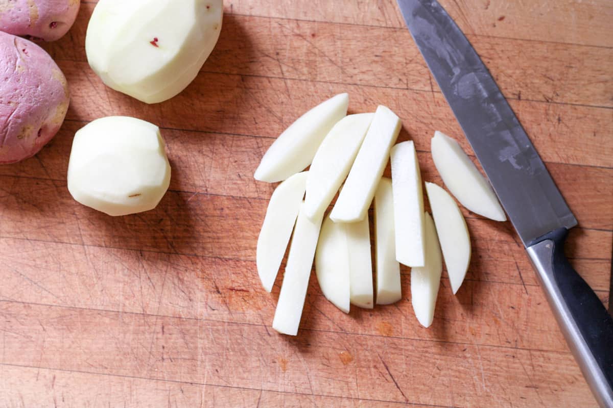 potatoes and knife on cutting board