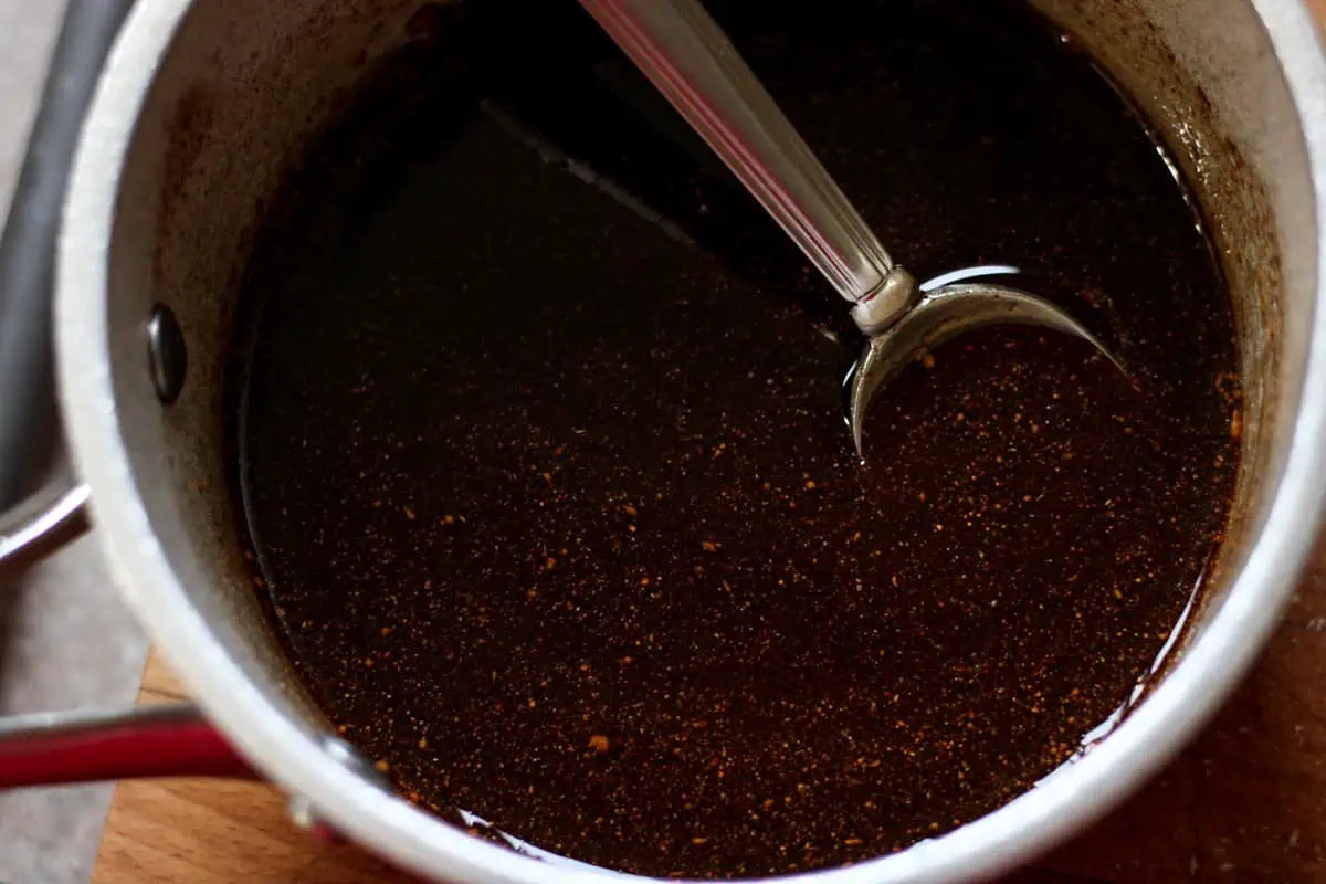brown liquid in a saucepan with a spoon