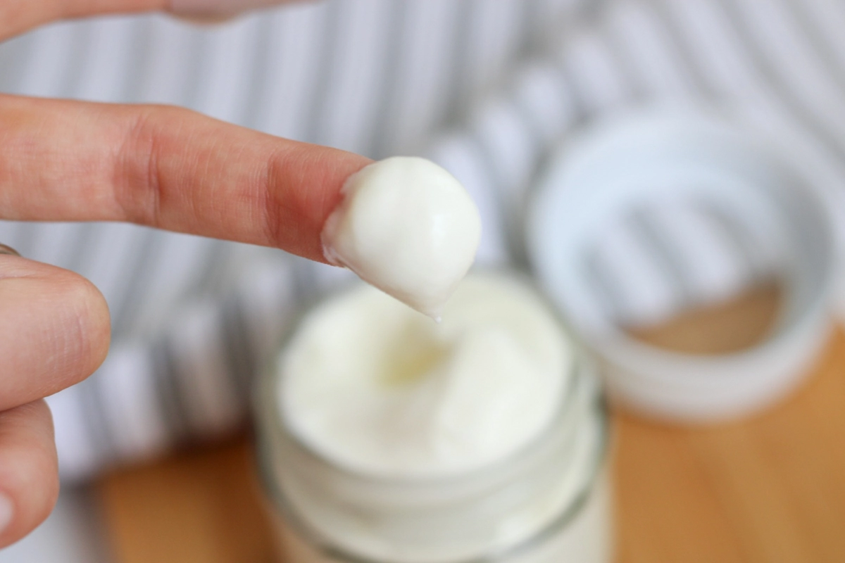 finger scooping tallow balm out of  a jar