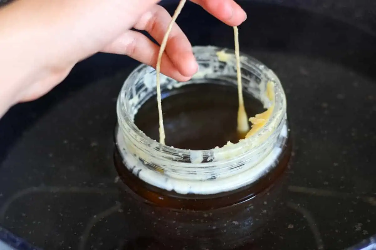 making dipped candles in a jar of wax in pot