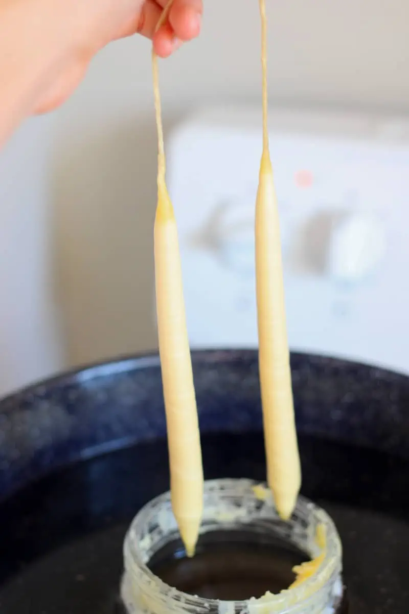 beeswax candles coming out of jar of wax