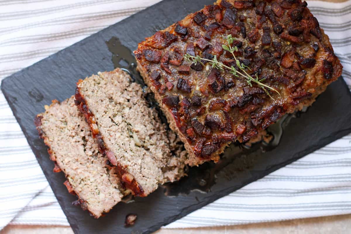 meatloaf on slate serving tray, cut in a few pieces