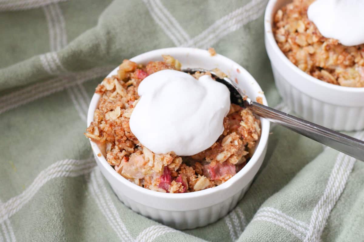 rhubarb crisp and whipped cream in a bowl