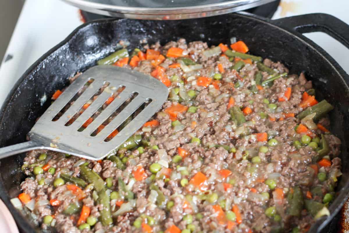 shepherds pie meat mixture in a skillet with flipper