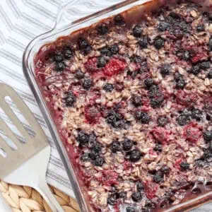 berry vegan baked oatmeal in dish with a serving utensil beside it