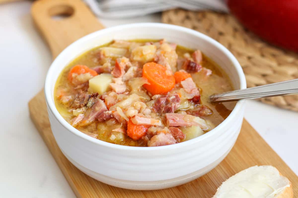 bowl of ham and bean soup on wooden board