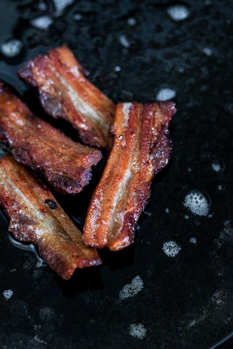 bacon frying in a cast iron pan
